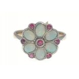 A 9ct gold opal ring with 6 opals and 7 red stones in a flower-head pattern, size M/N gross weight