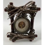 An unusual styled aneroid BAROMETER in a rustic looking wooden and string case, frame 16 x 14cm,