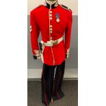 A SCOTS GUARDS CEREMONIAL UNIFORM comprising a bearskin and brass-decorated chinstrap, a red tunic