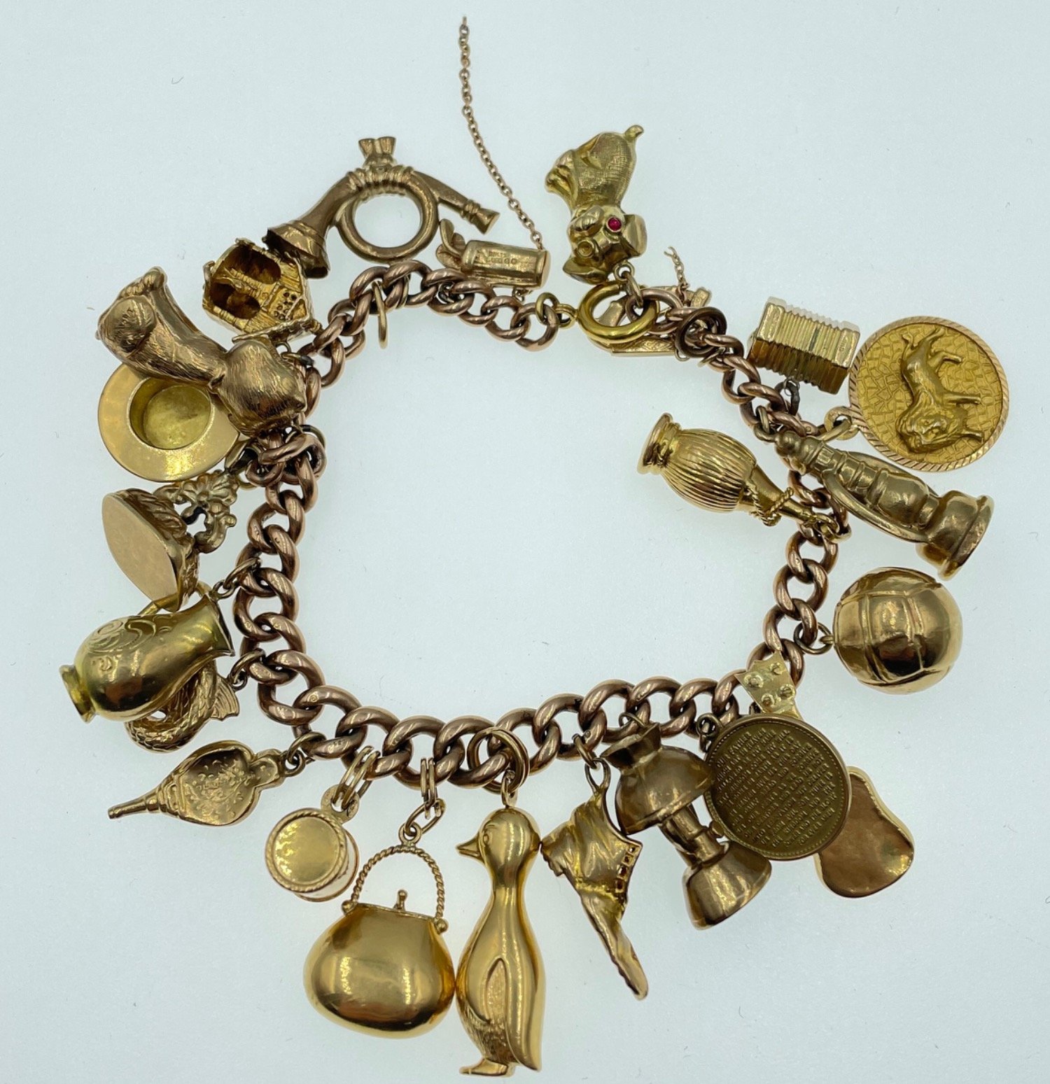 LOTS OF CHARMS!A 375 stamped gold charm bracelet , the 375 is partially rubbed, with most charms