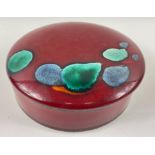 A striking vintage POOLE POTTERY trinket dish with lid in a vibrant red with green/blue highlights