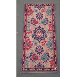A VINTAGE HANDMADE carpet pink base colour with floral style patterns in blues and red -