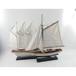 Two impressive model sailing boats on stands one with three masts stands approx 50cm tall, the