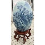 A SUBSTANTIAL ceramic blue and white egg with flora and fauna decoration on an oriental style