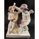 A grouping of two cherubs, possibly Meissen, with one playing the mandolin and the other holding a