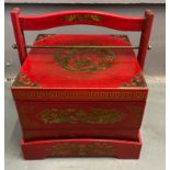 An ORIENTAL HIGHLY decorative red, gold and black painted and lacquered layer with carry handle