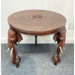 An INDIAN inspired hand carved side table with elephant head and tusks form legs - there is no