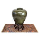 A Large Terracotta Glazed Pot with Wooden Stand