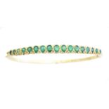 An 18ct gold emerald hinged bangle,