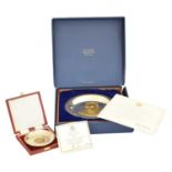A silver plate and gold commemorative plate,