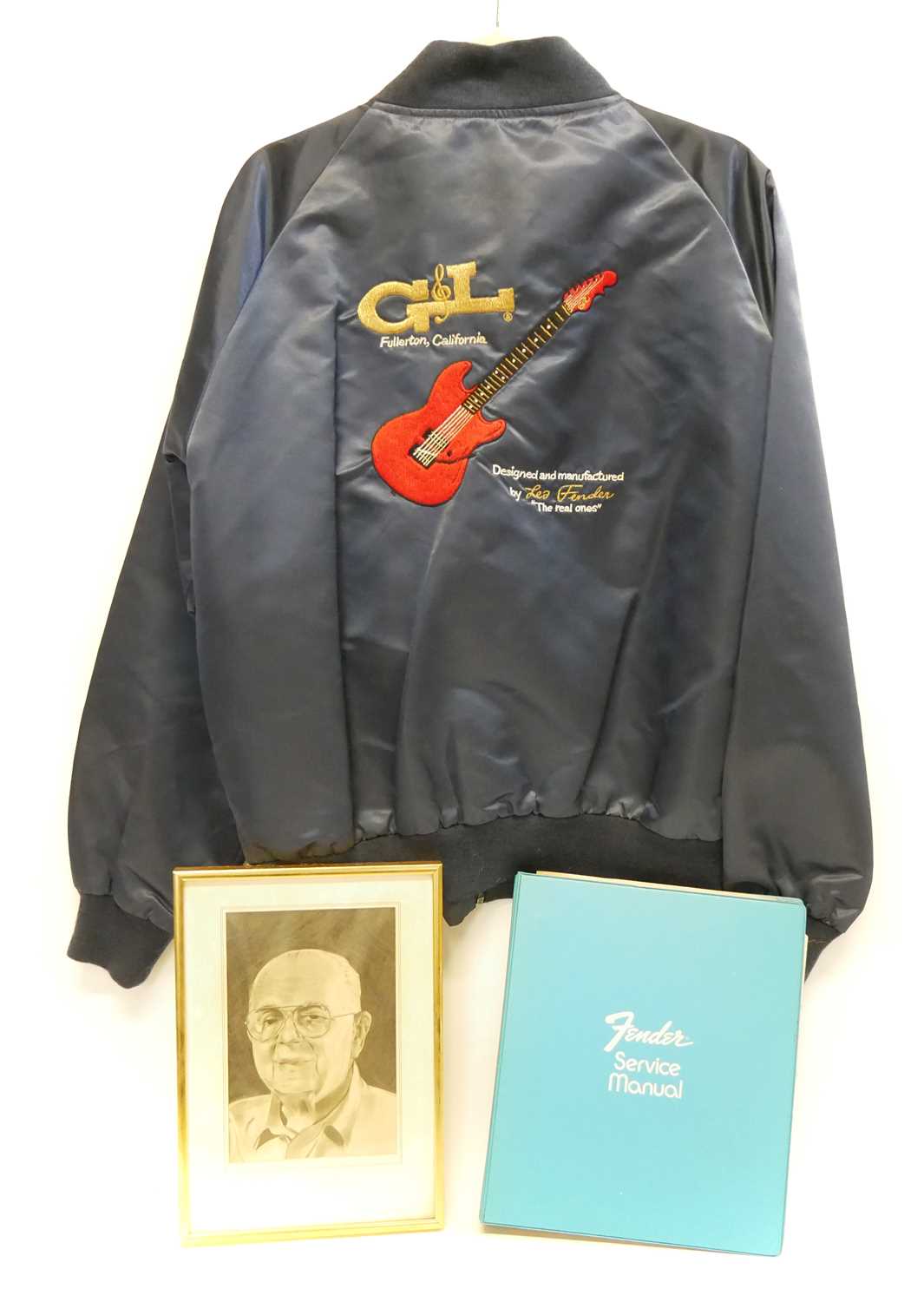 G&L Fender jacket, Fender Service manual and a pencil drawing of Leo Fender