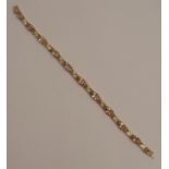 A pale smoky quartz set bracelet, stamped '375', the ten oval cuts alternate set with open work