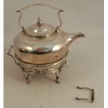 A silver spirit kettle on stand, the kettle with fixed handle over, the stand formed as a basket