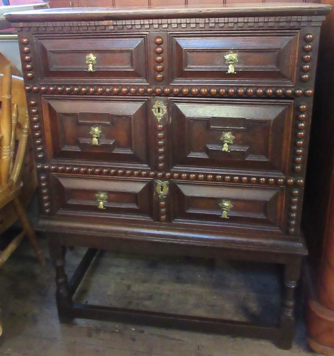 A 17th century style oak moulded front and bobbin moulded chest, of three long drawers, raised on