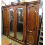 A 19th century break front walnut wardrobe, having two end hanging sections, fitted with four long