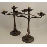 A pair of Arts and Crafts copper candlesticks, with central candle holder and two open work branches