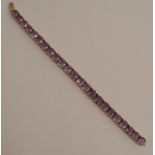 An amethyst 9 carat gold bracelet, set with twenty three cushion shaped stones, 19cm long, 21g