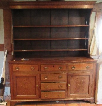 A Georgian cupboard dresser, with an associated close boarded Delft rack over three frieze