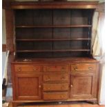 A Georgian cupboard dresser, with an associated close boarded Delft rack over three frieze