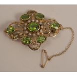 A peridot and cultured pearl Victorian style brooch, set with seven oval cuts, 4.9cm across, 11.7g