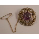 An Edwardian amethyst and seed pearl brooch, with a safety chain, 2.3cm diameter, stamped '9ct', 4.