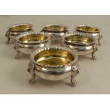 A set of six Scottish silver table salts, of circular form with shaped edge, raised on four lion