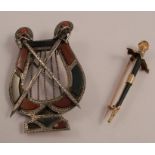 A Scottish pebble brooch, in the form of a lyre overlaid with crossed claymores, 5.7cm high by 3.8cm