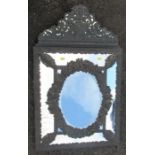 A metal framed wall mirror, the mirrored panels framed by floral metal strips and a metal frieze,