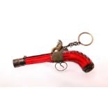 A novelty ruby red scent bottle, in the shape of a pistol, a registration mark on the trigger guard,