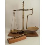 A pair of 19th century brass pharmacy scales, on a mahogany base, with four sets of brass weights,