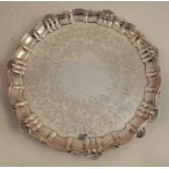 A Victorian silver salver, with scroll and shell edge and engraved decoration, raised on four scroll