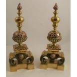 A tall pair of Regency Baroque style brass and copper andirons, on ogee style bases, with pierced