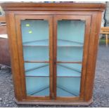 An oak corner cabinet, having a pair of glazed doors, height 40ins, width 37ins, depth 20ins