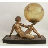 An Art Deco style lamp, formed as a seated gilt female figure holding an amber glass ball, on a