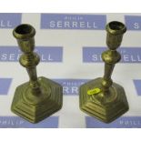 A pair of early 18th century brass candle sticks, raised on hexagonal bases, heights 7ins