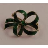 A green enamelled bow brooch, stamped '18', 2.9cm long, approximately 6g gross