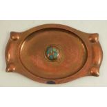 An Arts and Crafts copper tray, of shaped oval form, with hammered surface, the centre with