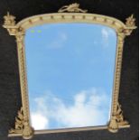 A gilt framed over mantel mirror, with leaf and ball decoration to the curved top and twist