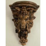 A Victorian wall bracket, the shaped shelf supported by a rams mask and grape vine, height 8.