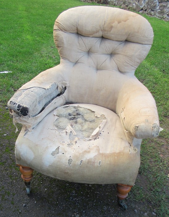 A Victorian upholstered armchair, with button back, on turned front supports, stamped C Hindley &