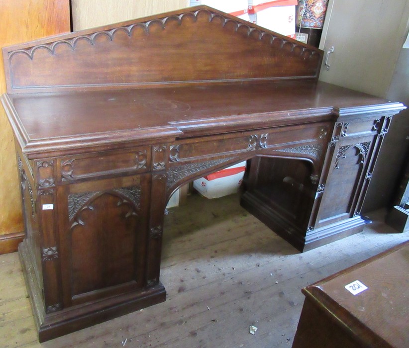 A late 19th century oak sideboard, with carved triangular back, fitted with a central drawer flanked