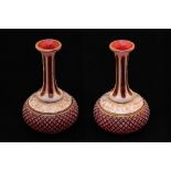 A matched pair of Bohemian ruby red glass vases, cut through from white to red with gilded