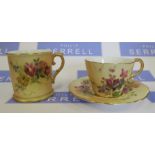 A Royal Worcester blush ivory tea cup and saucer, decorated with flowers, dated 1905, together