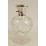 A glass dressing table scent bottle, with silver cap, the hinged silver lid set with mahogany, the