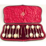 A cased set of twelve silver gilt tea spoons and sugar tongs, each with different decoration, London