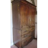 A late Georgian mahogany linen press, having two blind doors opening to reveal 5 pull out trays,