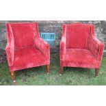 Two Edwardian upholstered fire side armchairs, raised on front tapering square oak legs,