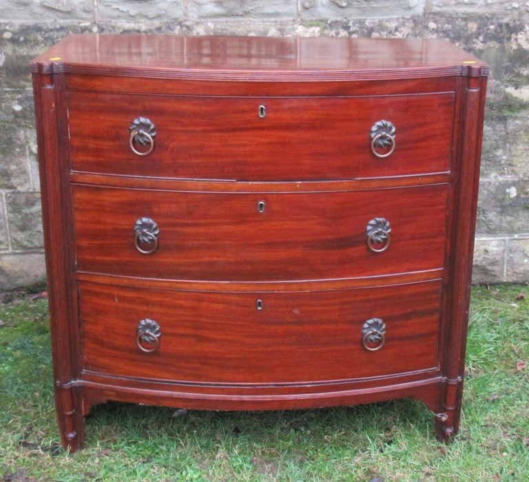 A bow front chest, of three long drawers flanked by reeded columns, width 37ins x depth 22ins x