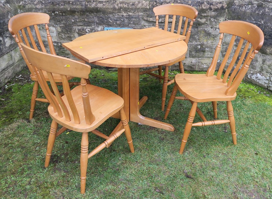 A circular oak extending table, diameter 35ins, together with a set of four modern Windsor kitchen