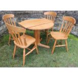 A circular oak extending table, diameter 35ins, together with a set of four modern Windsor kitchen